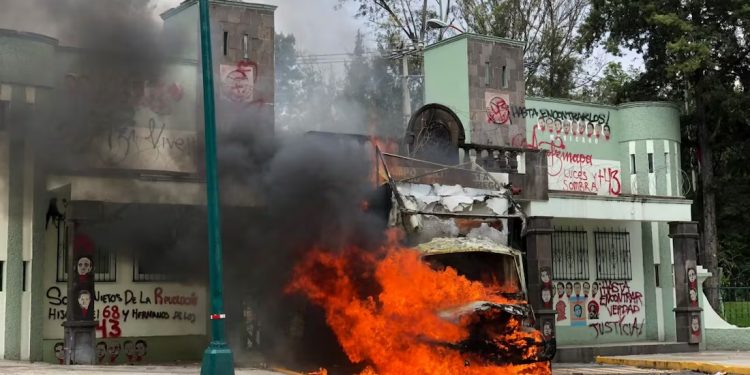 Normalistas de Ayotzinapa incendian camión para derribar puerta del Campo Militar Número Uno